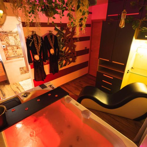 Jacuzzi privatif avec fauteuil Tantra dans la love room La Boudoir près de Genève pour une escapade romantique.